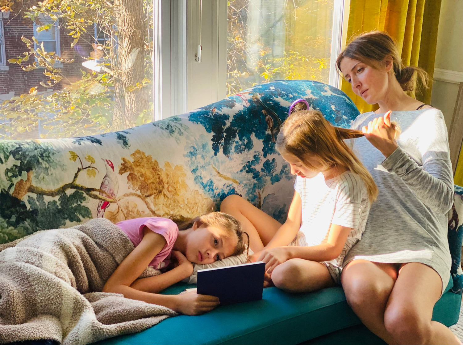 Author Sarah Majdov at home with her daughters, a quiet moment of reading and reflection.